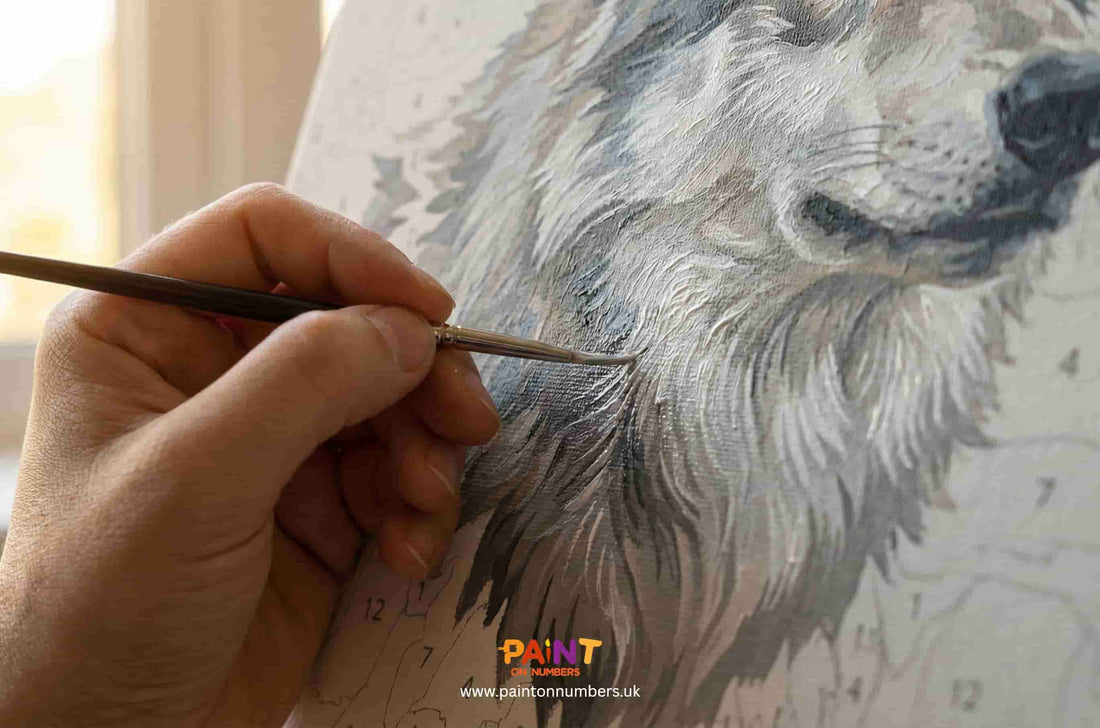 A person painting a detailed portrait of a dog with a brush, using the 'Paint On Numbers' brand.
