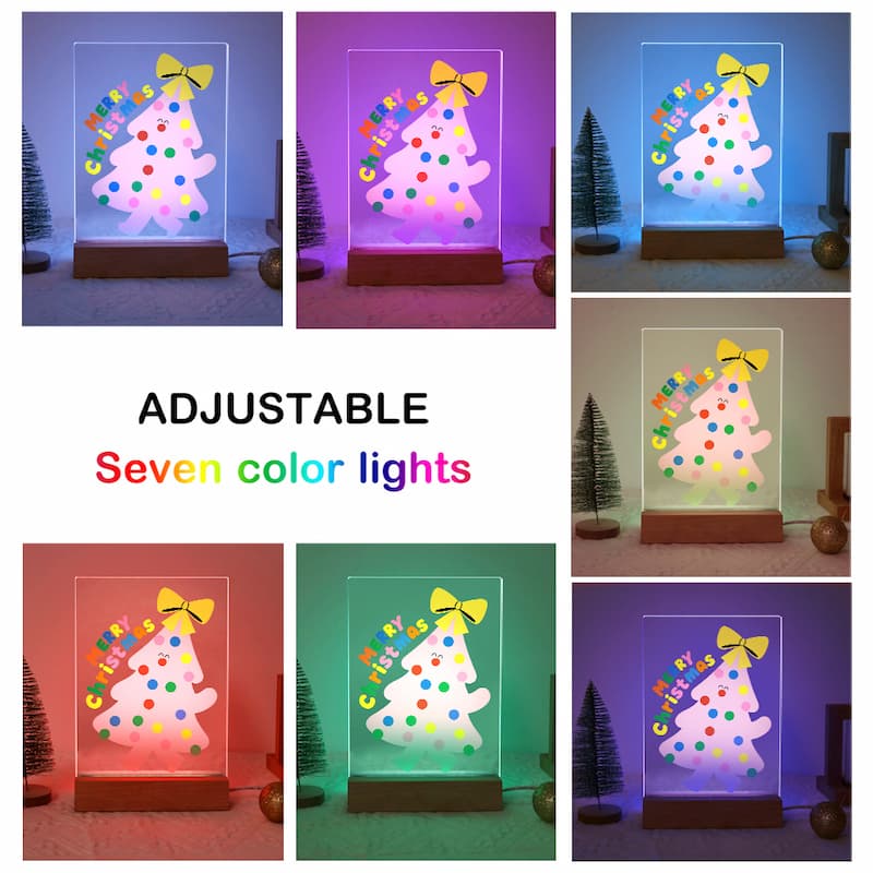 A collage showing a glowing Christmas tree night light in seven different color modes, with text in the center reading 'ADJUSTABLE Seven color lights'. The product has a clear acrylic panel, a multicolored polka-dot tree design, a yellow bow, and a wooden base.