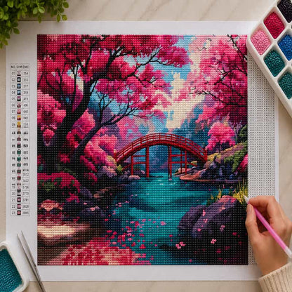 Diamond painting kit with a completed artwork of a cherry blossom tree and red bridge.
