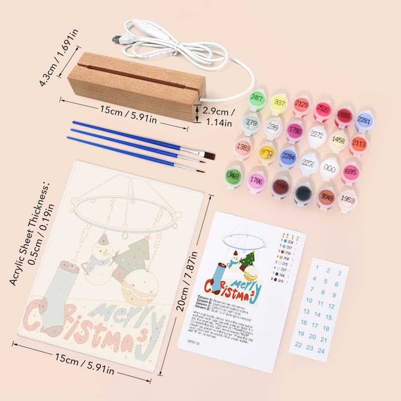 Merry Christmas canvas painting kit with a wooden electric heater, 16 colorful paint pots, two blue paintbrushes, an acrylic sheet with a snowman design, a color chart, and a number grid on a light beige background with dimension annotations.