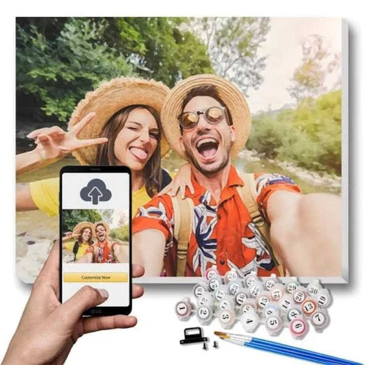 Two people taking a selfie outdoors with a phone displaying an app interface, surrounded by paint bottles and brushes.