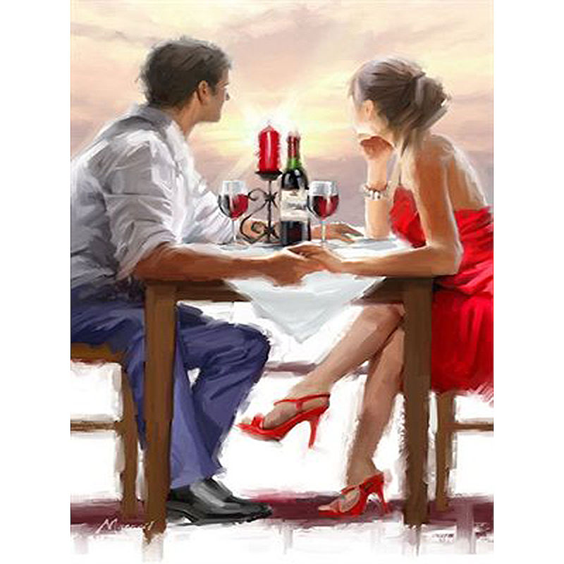 Couple on a romantic dinner date with candles and wine glasses.