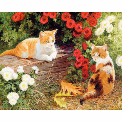 Two cats on a log with flowers and leaves in the garden