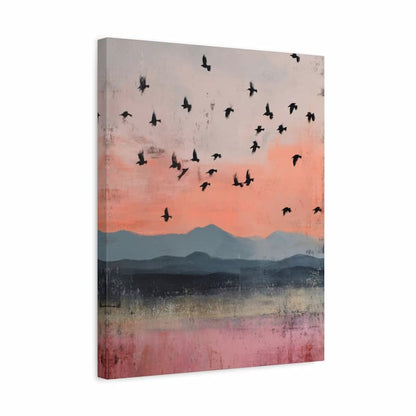 A vertical canvas wall art print depicting a sunset landscape with flying black birds over layered blue and pink mountains, shown at a slight angle on a white background.