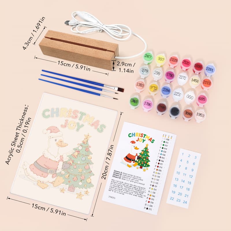 Christmas DIY canvas painting kit with a wooden frame, acrylic paint bottles, two paintbrushes, and a canvas sheet showing a cartoon duck decorating a Christmas tree, laid out on a beige background with printed dimensions.