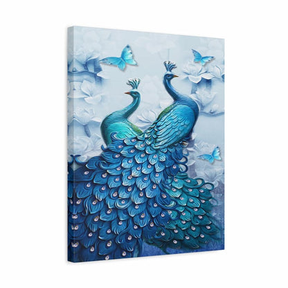 A square canvas wall art print featuring two blue peacocks with elaborate feathered tails, surrounded by white flowers and light blue butterflies on a pale blue background.