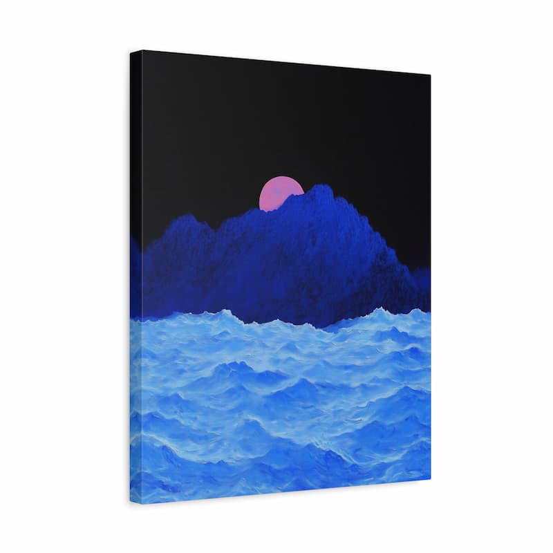A vertical canvas wall art print depicting a stylized landscape with blue ocean waves in the foreground, a dark blue mountain range, and a pink sun against a black sky, shown at a slight angle on a white background.