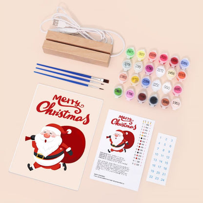 Artistic painting kit with Christmas-themed cards, paintbrushes, and paint on a beige background