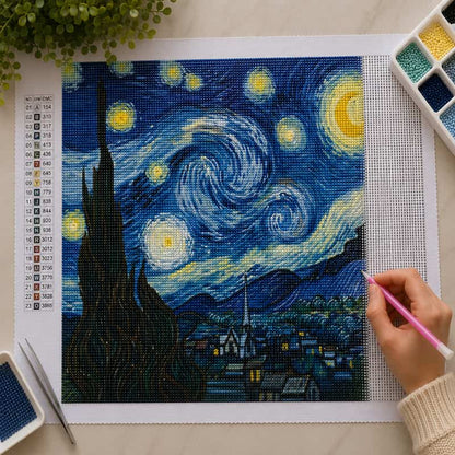 DIY diamond painting kit of 'Starry Night' with a hand using a tool.