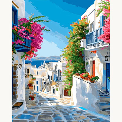 Colorful Mediterranean street with white buildings, blue doors, and flowers.