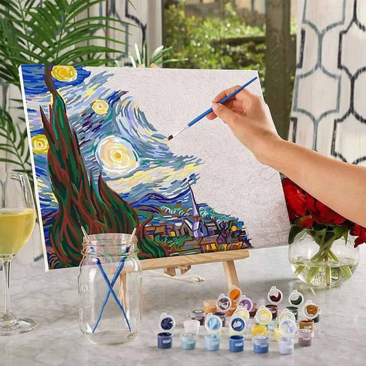 Person painting a replica of 'The Starry Night' with art supplies on a table.